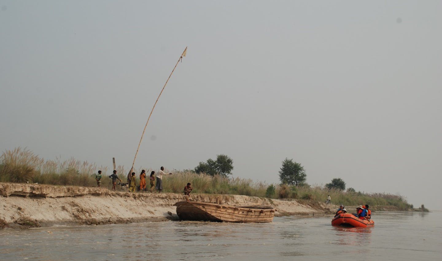 The expedition boats stood in contrast to the villagers' wooden work boats. Above, the team encountered a ferry. The pole is a sign able to be seen from long distances.