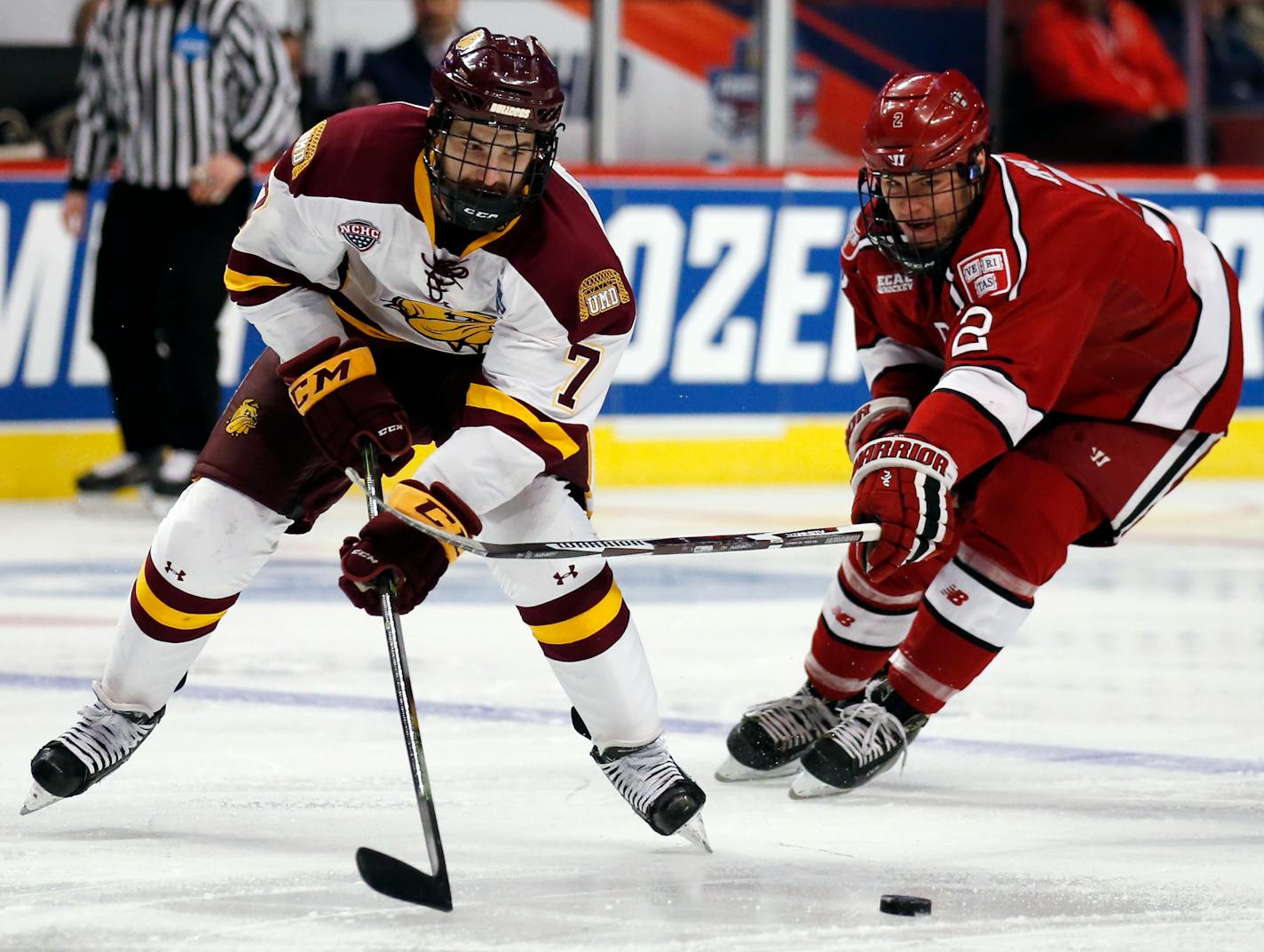 CORRECTS TO MINNESOTA-DULUTH, INSTEAD OF MINNESOTA - Minnesota-Duluth center Adam Johnson, left, and Harvard right wing Tyler Moy chase the puck during the first period of an NCAA Frozen Four men's college hockey semifinal, Thursday, April 6, 2017, in Chicago. (AP Photo/Nam Y. Huh)