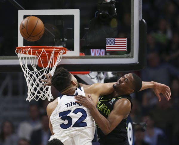 Minnesota Timberwolves center Karl-Anthony Towns (32) defended Atlanta Hawks guard Isaiah Taylor (22) as he shot in the fourth quarter.