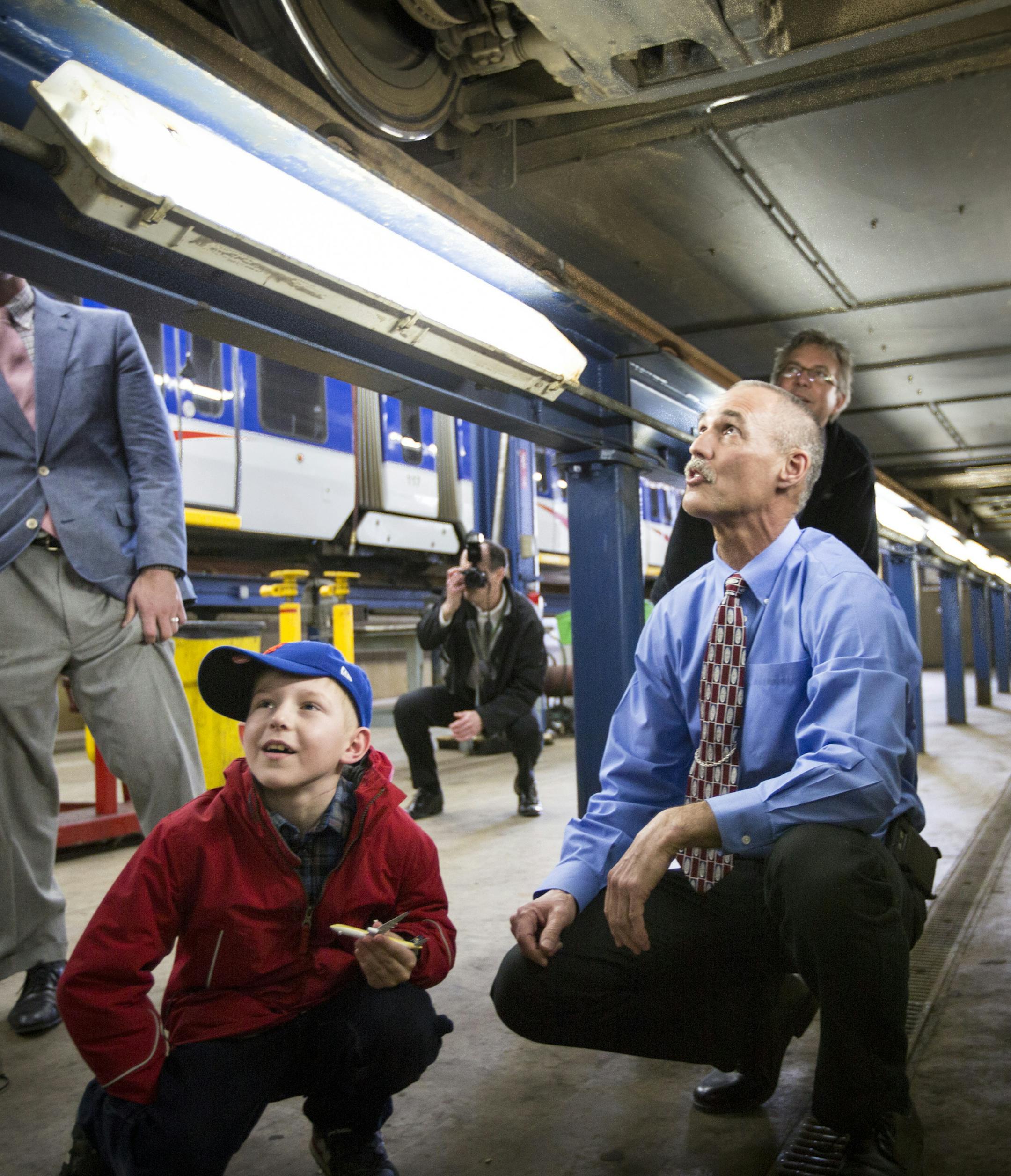 Director of LRT vehicle maintenance Rick Carey, right, gave 8-year-old "trainiac" Karlis Barobs a tour of the LRT Hiawatha Maintenance & Operation Center including under a train on Monday, March 21, 2016, in Minneapolis, Minn. ] RENEE JONES SCHNEIDER • reneejones@startribune.com