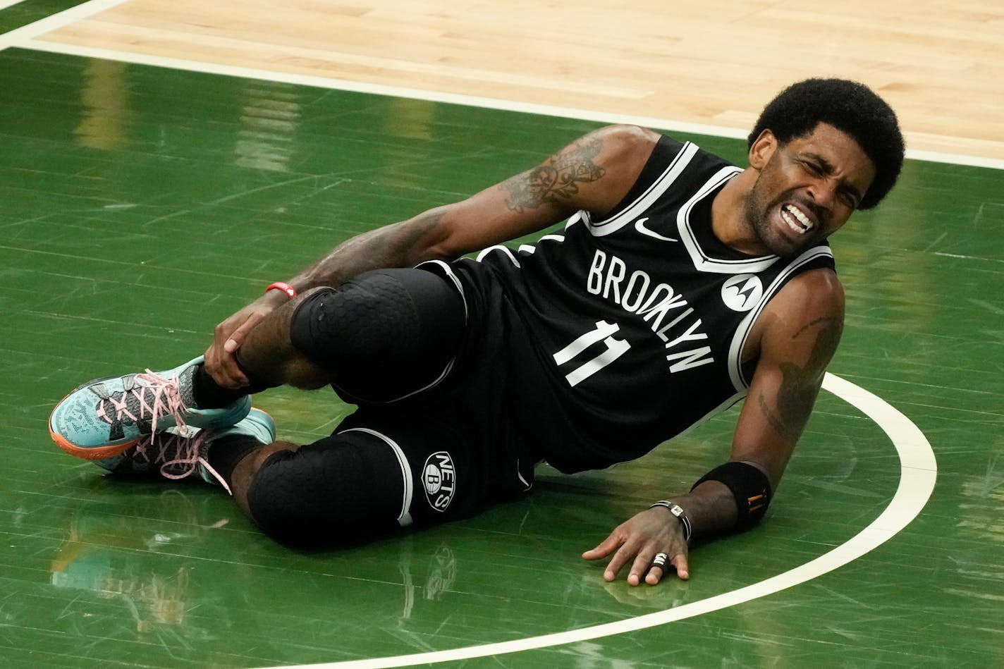 Brooklyn Nets' Kyrie Irving holds his leg after being injured during the first half of Game 4 of the NBA Eastern Conference basketball semifinals game against the Milwaukee Bucks Sunday, June 13, 2021, in Milwaukee. (AP Photo/Morry Gash)