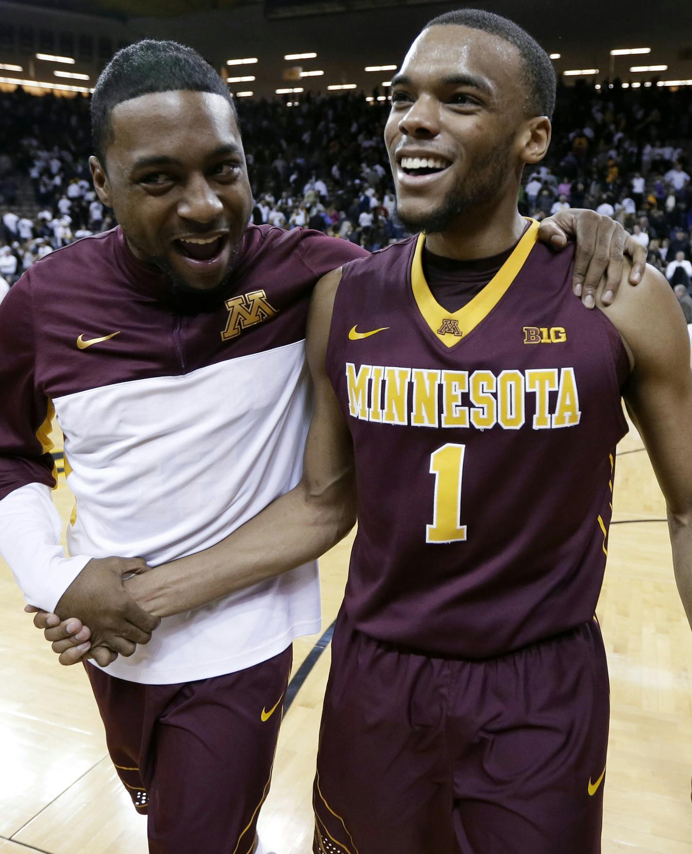 Minnesota guard Andre Hollins, right, celebrates with a teammate after an NCAA college basketball game against Iowa, Thursday, Feb. 12, 2015, in Iowa City, Iowa. Hollis scored 20 points as Minnesota won 64-59. (AP Photo/Charlie Neibergall)