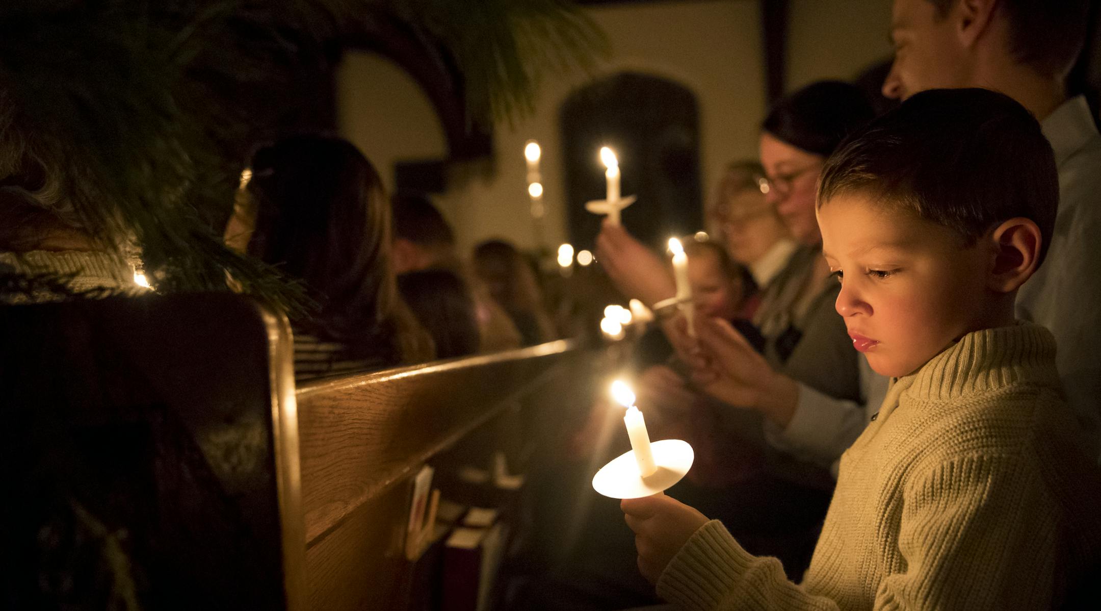 Evan Dahl, 5, of St. Paul, held a candle while sitting with his family as the congregation sang Night of Silence/ Silent Night during a Christmas Eve service at Plymouth Congregational Church on Sunday, December 24, 2017, in Minneapolis, Minn. ] RENEE JONES SCHNEIDER ¥ renee.jones@startribune.com