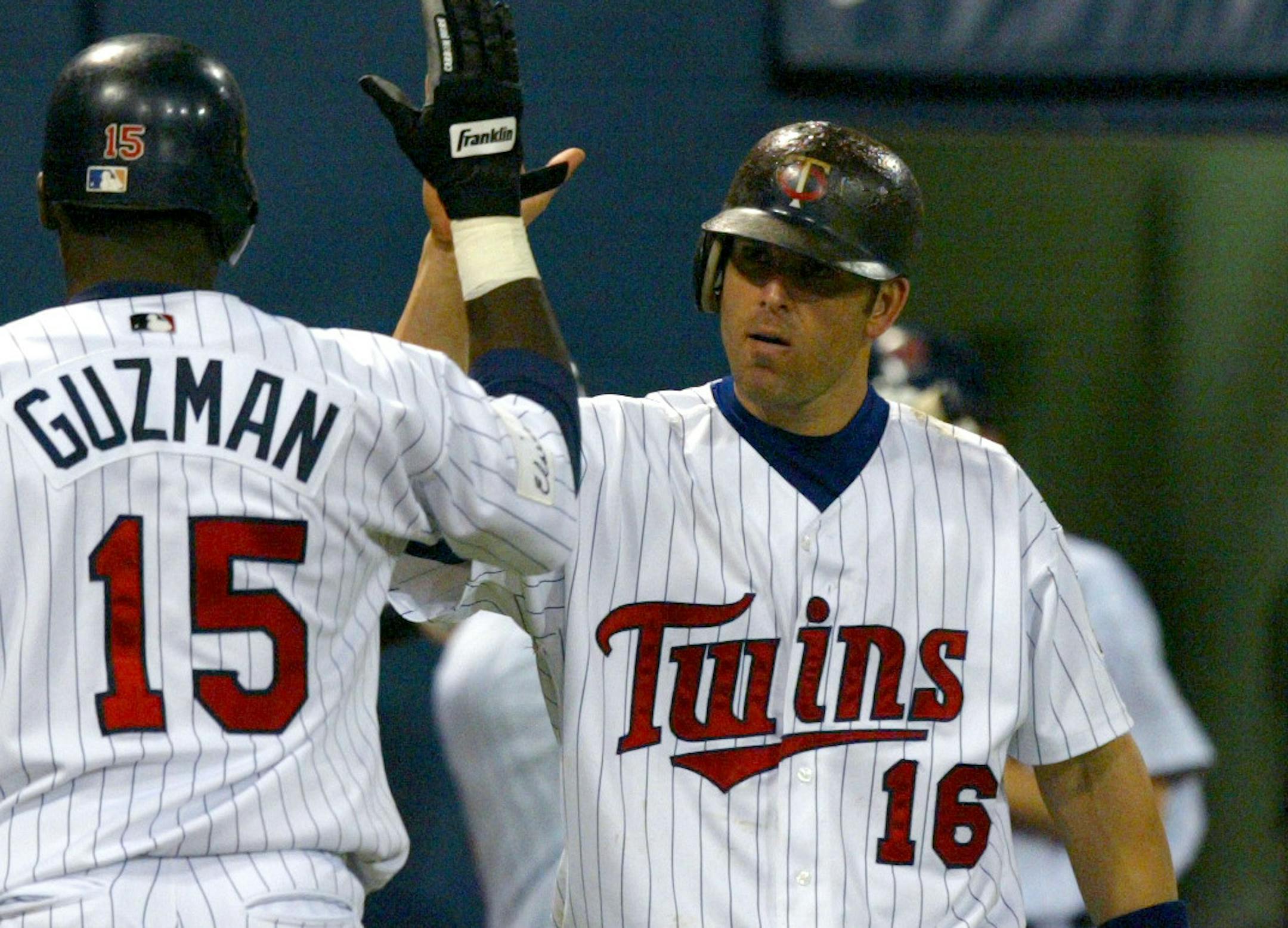 Staff photo by Jeff Wheeler
MINNEAPOLIS - 6/25/04 - The Twins began an interleague series against the Milwaukee Brewers with a 6 -3 victory Friday night at the Metrodome. IN THIS PHOTO: Doug Mientkiewicz congratulates Cristian Guzman on his seventh inning home run Friday night while on his way to the plate.