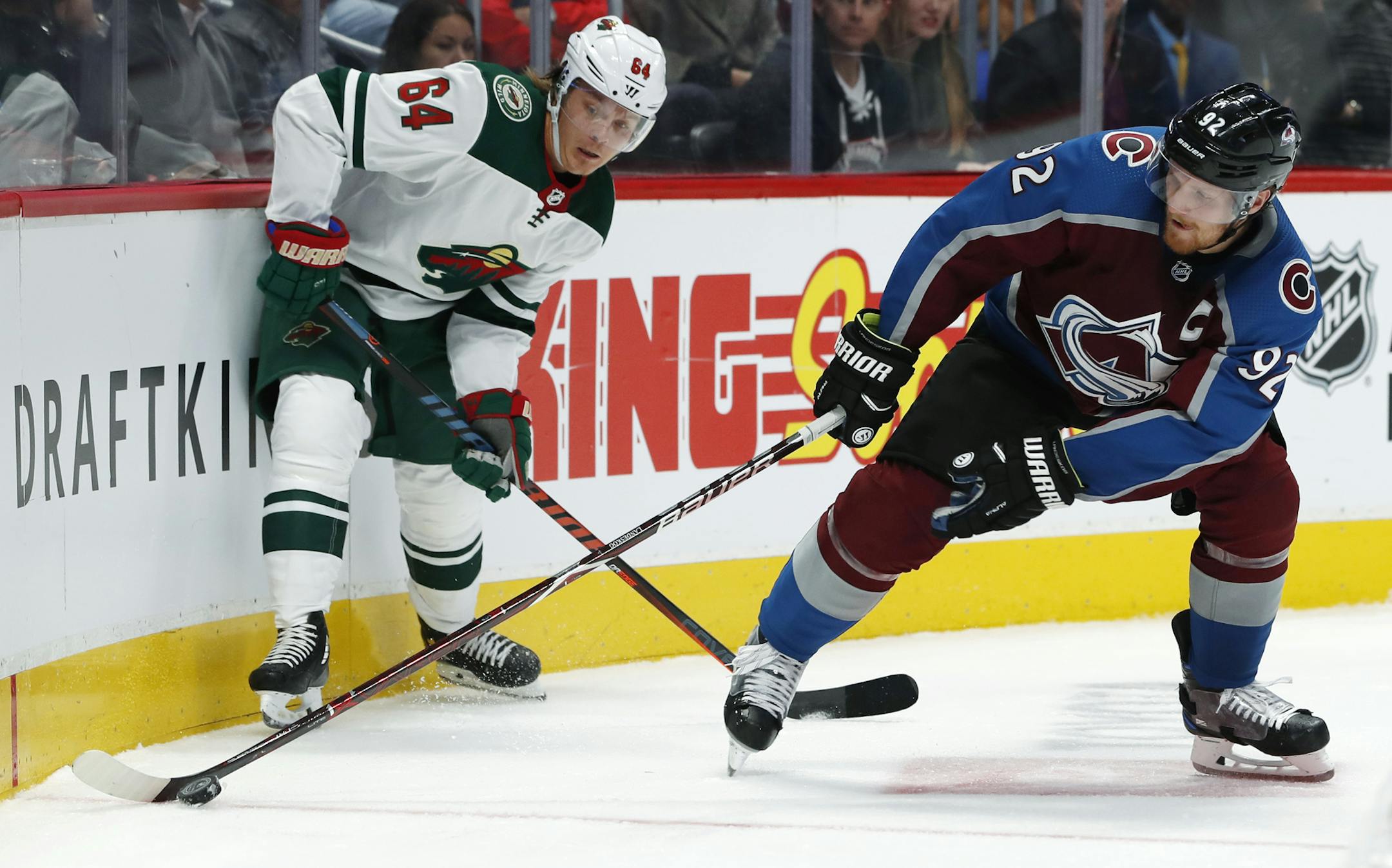 Colorado Avalanche left wing Gabriel Landeskog, right, reaches out for the puck as Minnesota Wild right wing Mikael Granlund defends during the second period of an NHL hockey game Thursday, Oct. 4, 2018, in Denver. (AP Photo/David Zalubowski)