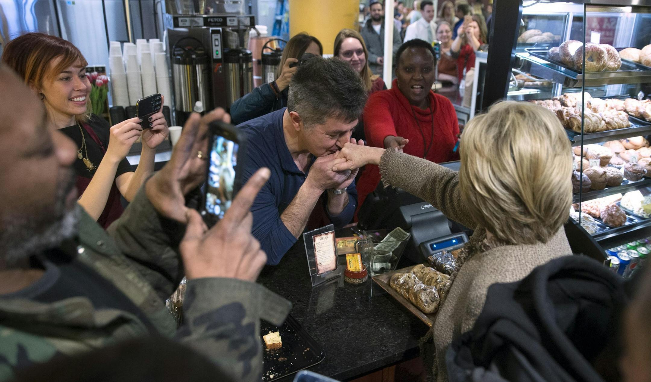 Hillary Clinton, a Democratic presidential hopeful, has her hand kissed by the store owner during a visit to Midtown Global Market in Minneapolis, Minn., March 1, 2016.