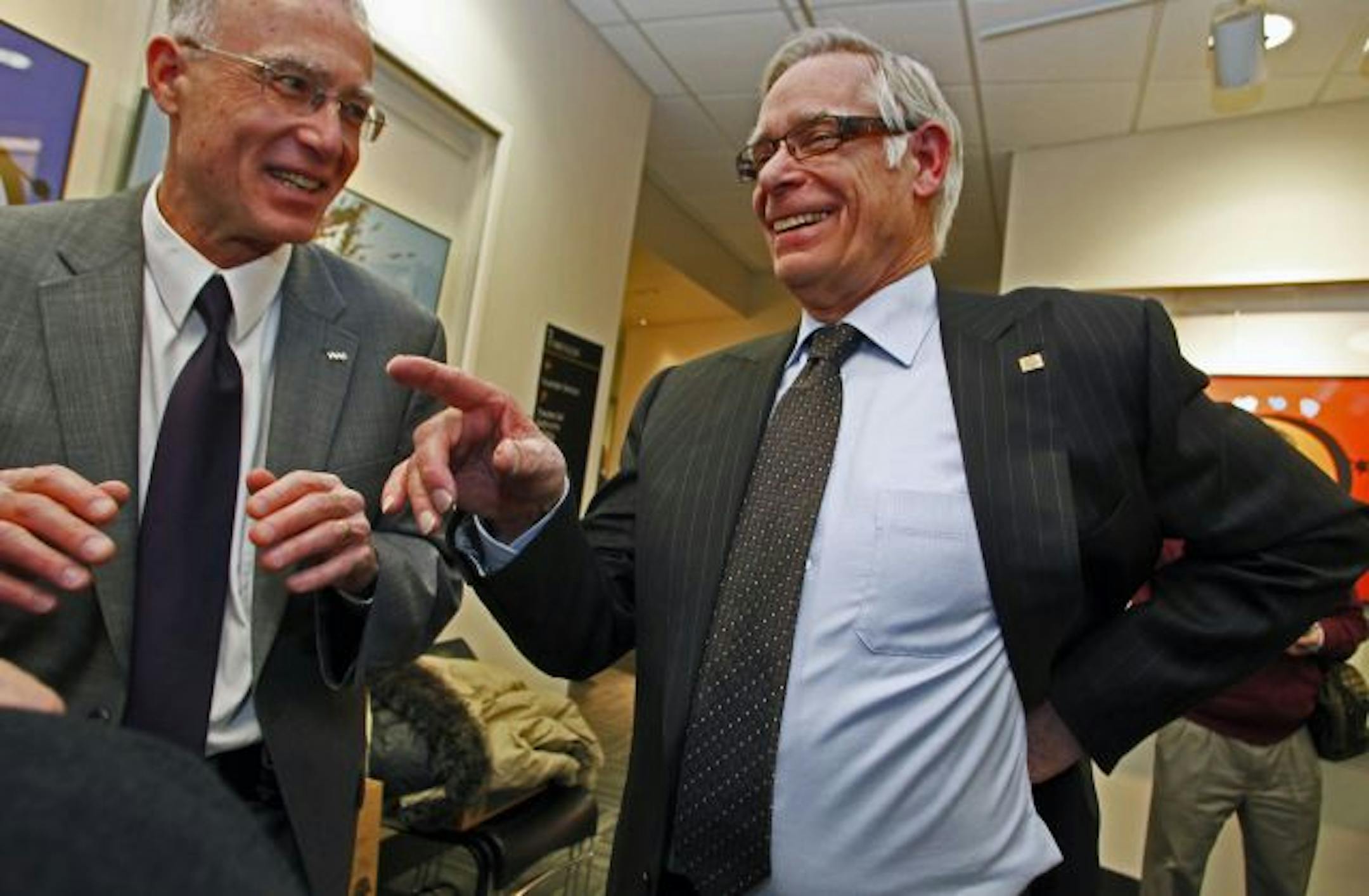U of M President Robert Bruininks, right, swapped stories with Greg Lindsey, acting dean of the Humphrey School of Public Affairs, after giving his final "State of the University" speech.