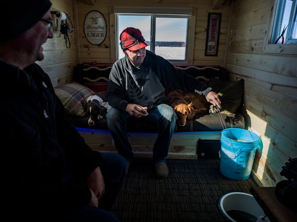 Unrelenting warmth has stunted Minnesota’s ice fishing season. In many places, the ice is too thin to support fish houses like this one — occupied