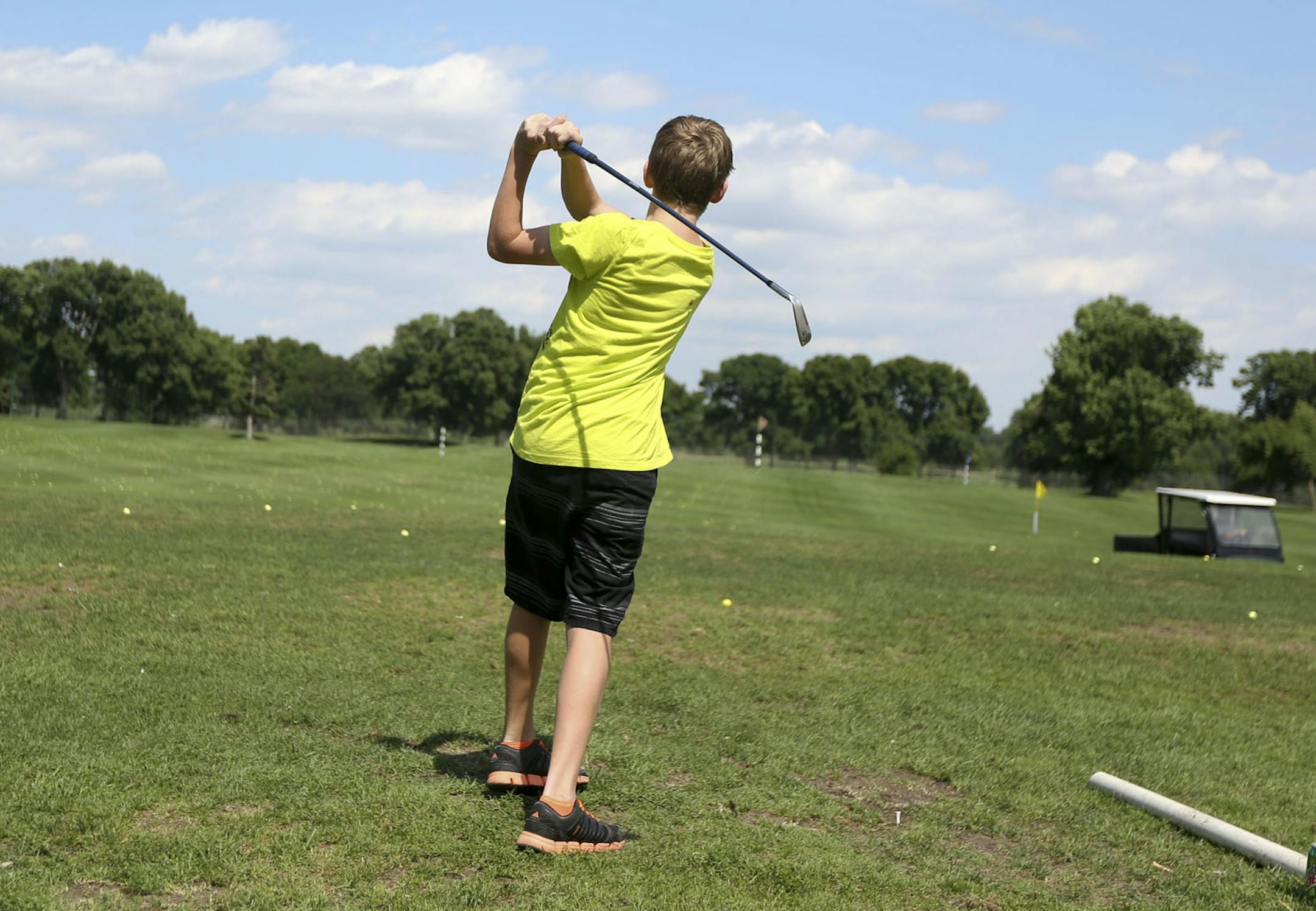 Brandon Braswell, 13, of Washington D.C. tried to out do his grandfather on the driving range at Hiawatha golf course in Minneapolis, Min., Thursday, August 1, 2013. ] (KYNDELL HARKNESS/STAR TRIBUNE) kyndell.harkness@startribune.com
