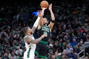 Celtics forward Jayson Tatum shoots against Bucks guard Damian Lillard on March 20. While the Celtics have maintained the best record in the league fo