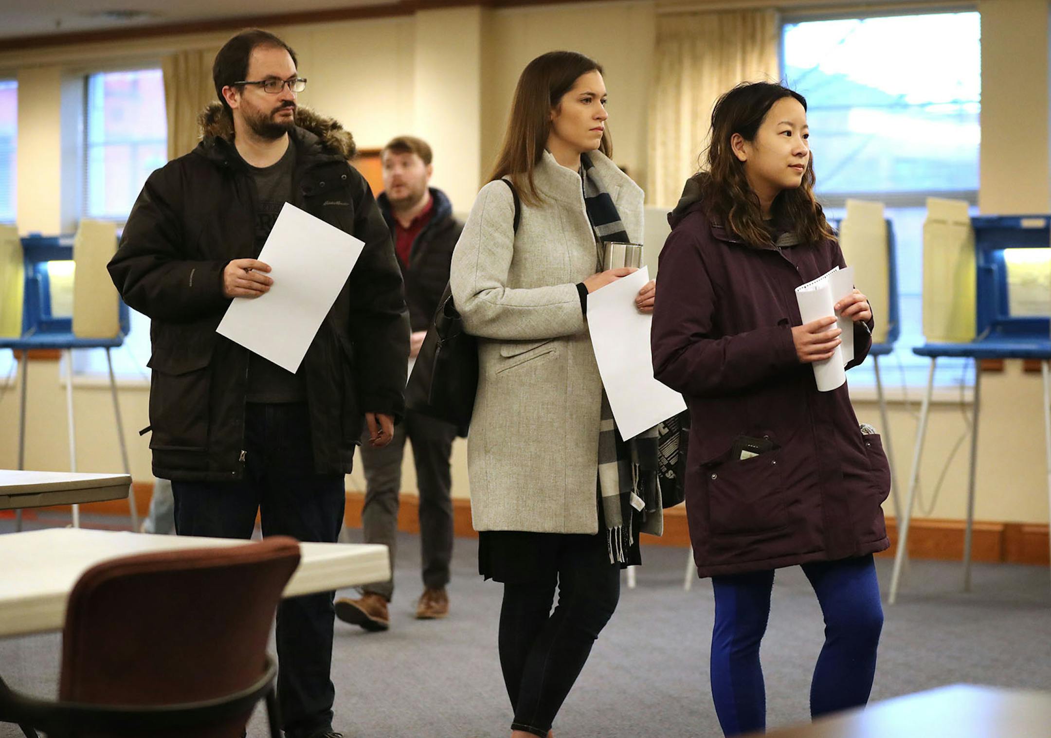 Voters wait to place their ballots in a ballot reader at Westminster Presbyterian Church in downtown Minneapolis for Tuesday's presidential primary.