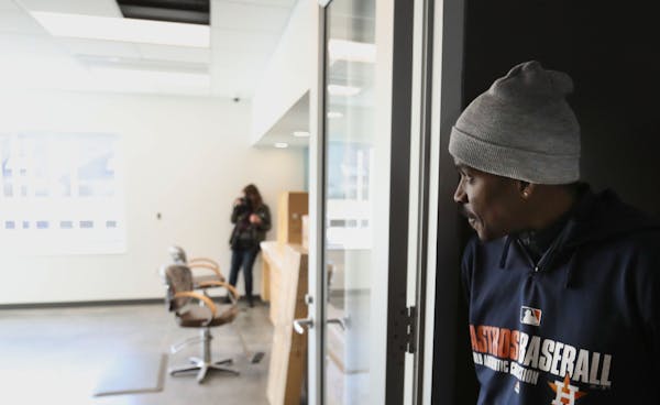 Antonio Kelly peeked into a salon where residents can get haircuts at Dorothy Day Place, where Kelly has an apartment after three years with no home.