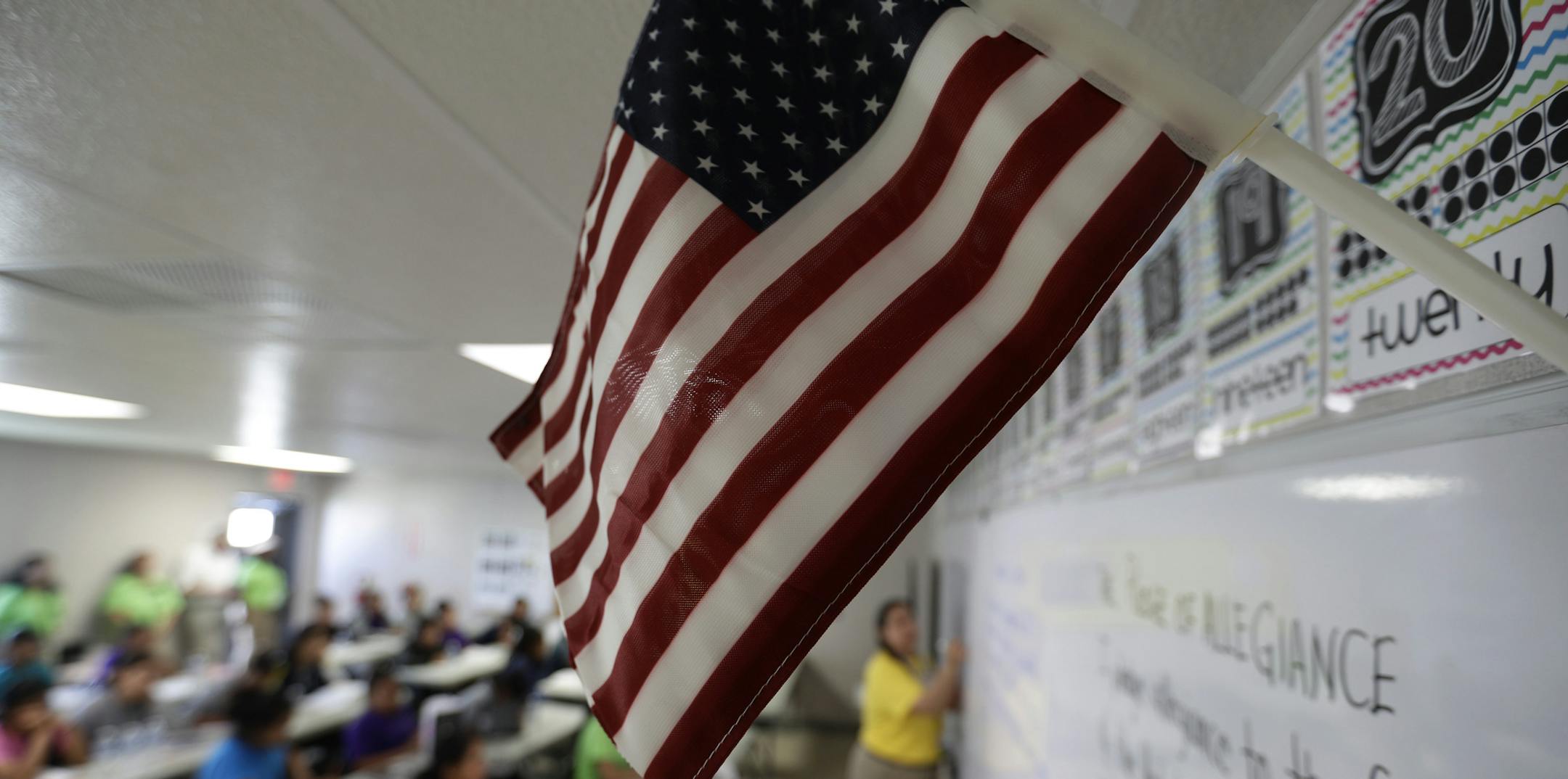 A teacher uses the Pledge of Allegiance in a reading class the U.S. government's newest holding center for migrant children in Carrizo Springs, Texas, Tuesday, July 9, 2019. (AP Photo/Eric Gay)