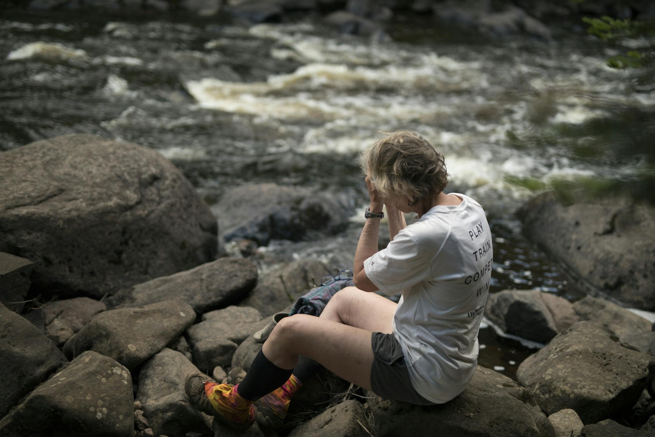 Day-11 - After arriving in camp at about 8:30p.m. with a long 20 mile day behind her, Melanie McManus, exhausted and dehydrated, rests by the Manitou River and washes up before making dinner and climbing into her hammock for the night.