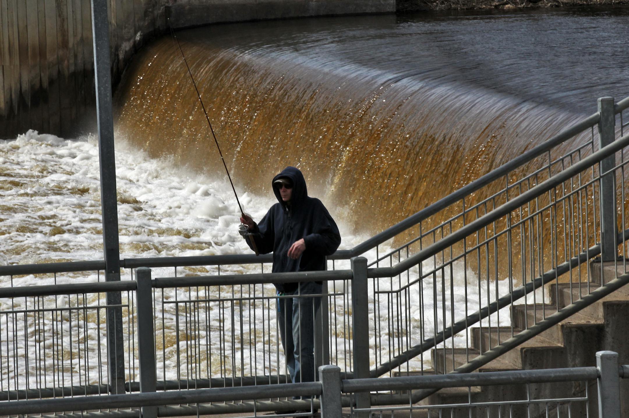 Anoka officials are planning on upgrading the Coon Rapids Dam on the Rum River in downtown Anoka to slow the downstream progress of the invasive Asian carp. Edward Rutter of New Hope fished just below the dam on a recent afternoon. (MARLIN LEVISON/STARTRIBUNE(mlevison@startribune.com (cq Edward Rutter )