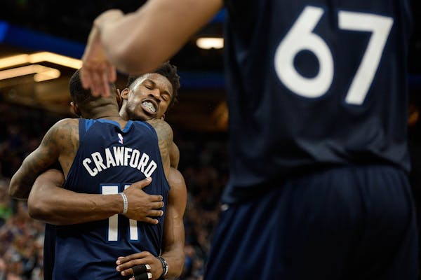 Minnesota Timberwolves guard Jimmy Butler (23) celebrated with guard Jamal Crawford (11) after their team's 128-125 victory over the Denver Nuggets.