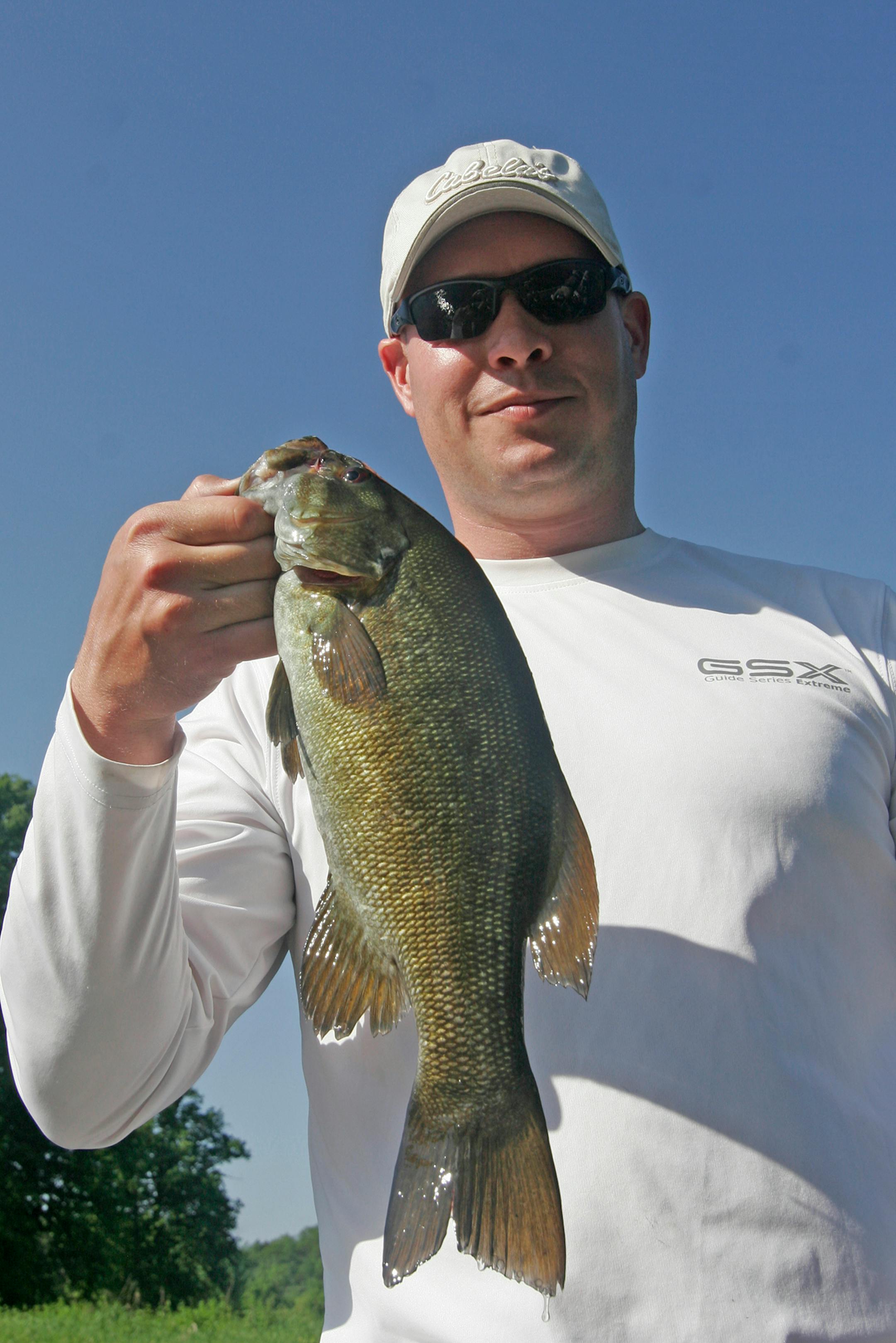 Nate Foster, 35, of St. Cloud, a veteran of the wars in Afganistan and Iraq, with one of several smallmouth bass he boated at the Trolling for the Troops event Friday at Camp Ripley. Some 86 veterans fished the Mississippi River and Lake Mille Lacs in the fourth annual event.