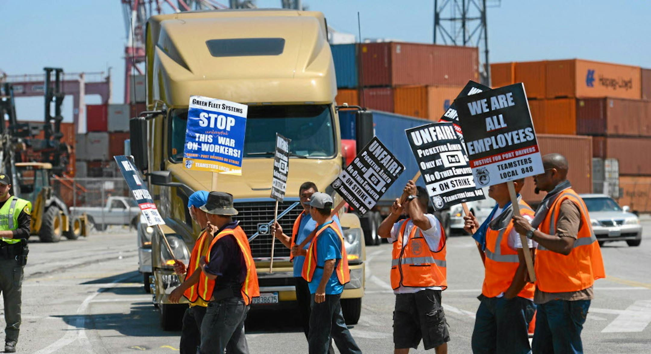 FILE - This July 8, 2014 file photo shows members of the Teamsters Union picketing at the Port of Long Beach, Calif., in support of a strike by port truck drivers. Negotiators seeking to avoid labor unrest at West Coast ports made significant progress with their announcement of a tentative deal on health care benefits, Tuesday, Aug. 26, 2014, a knotty issue that had tied up contract talks for months. (AP Photo/The Daily Breeze, Stephen Carr)