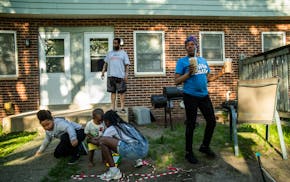 Shanda Davis enjoys an iced coffee surrounded by family outside their home at Glendale Townhomes in Minneapolis.
