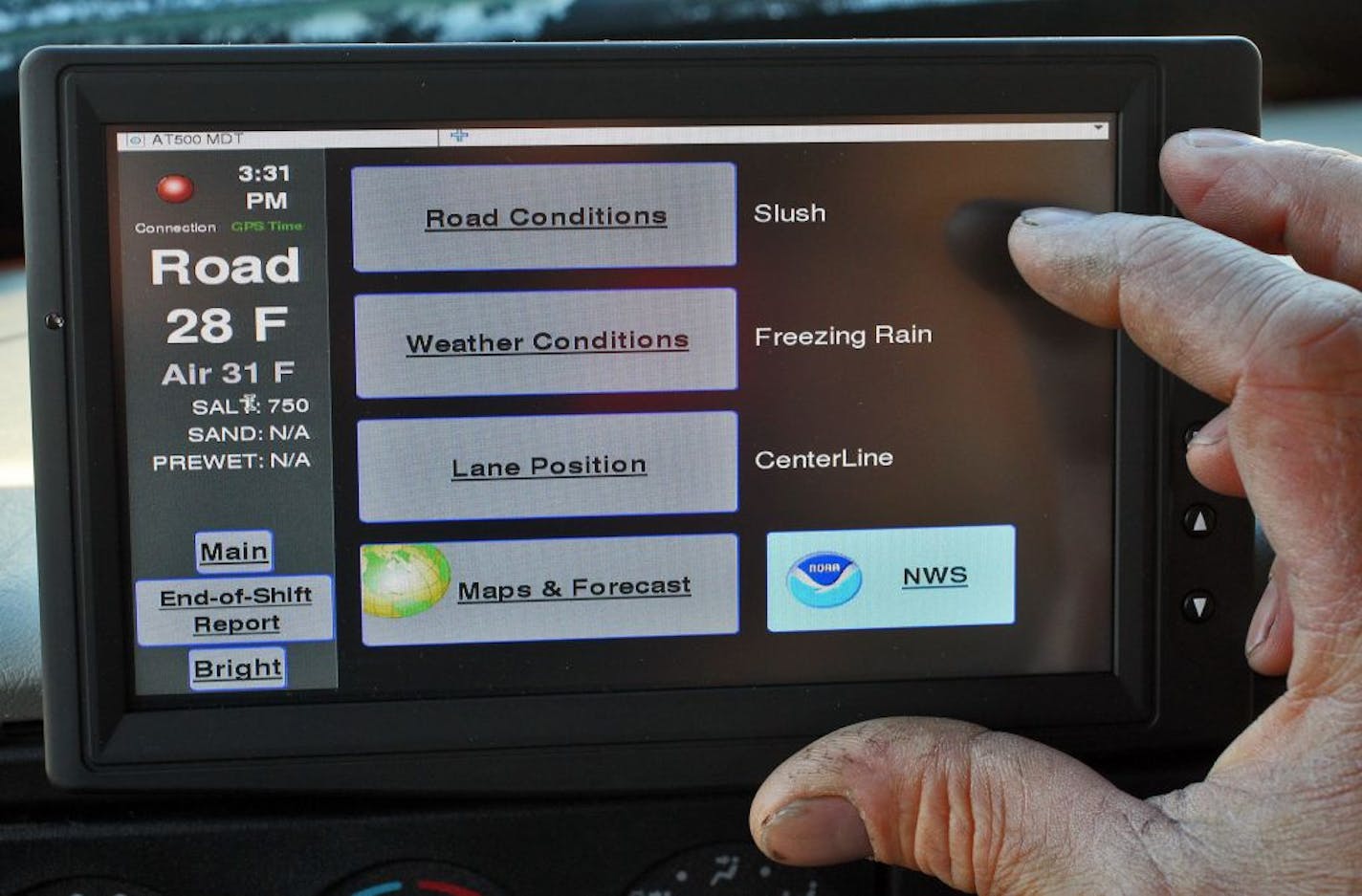 MNDOT is equiping plows with sensors that can read road conditions to combine with weather forecasts to determine where and how to plow fallen snow on area roads. The computer screen mounted on a truck dash showing a static readout.