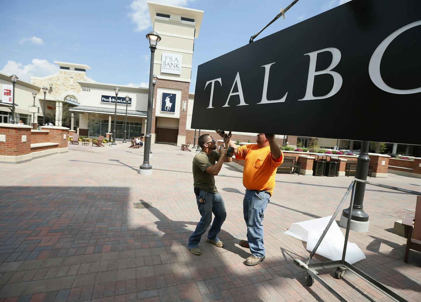 Mike Flatin left and Marco Miller were preparing to the hang the Talbots sign at the new outlet mall in Eagan Wednesday August 13 , 2014 in Eagan MN . The Mall with over 100 stores opens Thursday morning at at 10am. ] Jerry Holt Jerry.holt@startribune.com