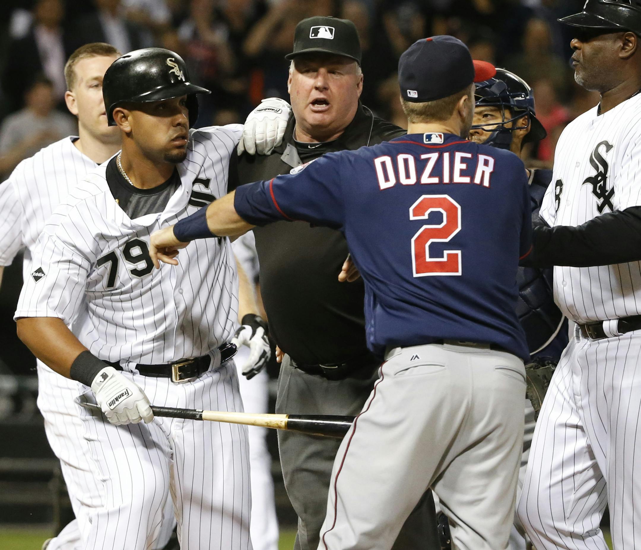 Minnesota Twins' Brian Dozier (2) comes off the bench and pushes Chicago White Sox's Jose Abreu (79) after Abreu was hit by a pitch from relief pitcher Trevor May during the eighth inning of a baseball game Friday, May 6, 2016, in Chicago. Watching the play are Todd Frazier, left, catcher Kurt Suzuki and first base coach Daryl Boston, right (AP Photo/Charles Rex Arbogast)