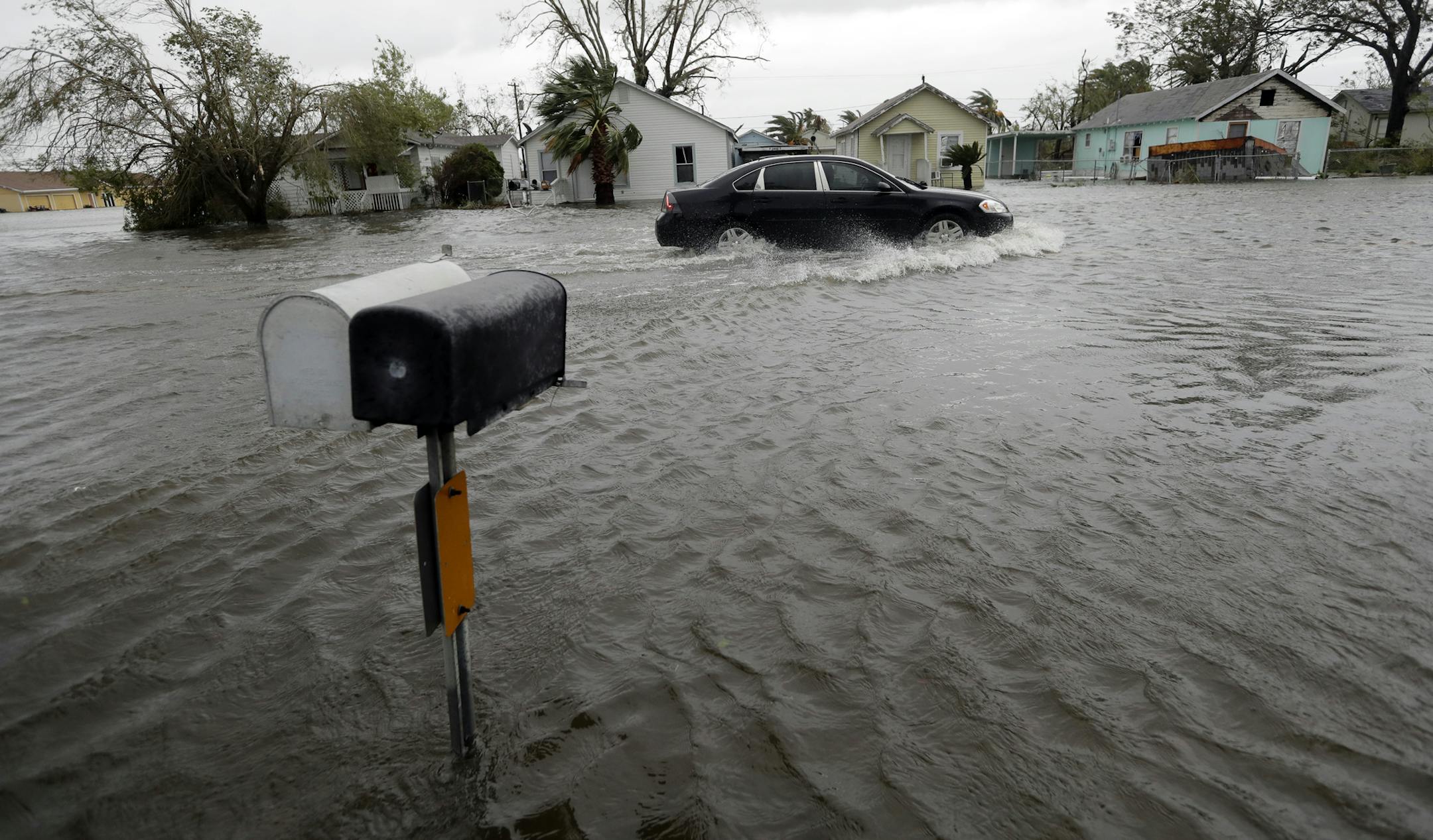 A drives moves through flood waters left behind by Hurricane Harvey, Saturday, Aug. 26, 2017, in Aransas Pass, Texas. Harvey rolled over the Texas Gulf Coast on Saturday, smashing homes and businesses and lashing the shore with wind and rain so intense that drivers were forced off the road because they could not see in front of them. (AP Photo/Eric Gay)