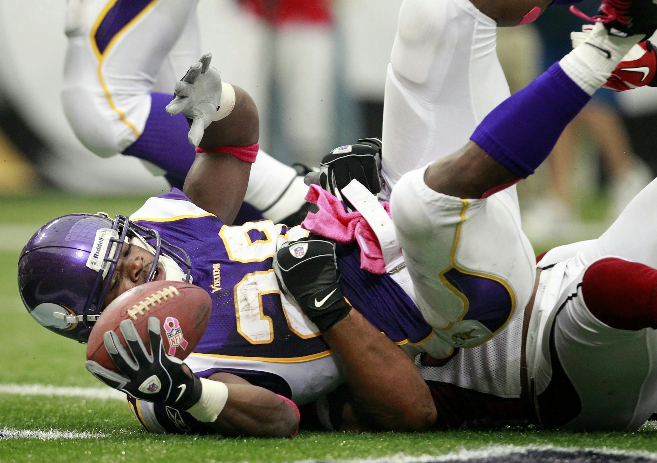 Vikings running back Adrian Peterson (28) pushed back Patrick Peterson (21) as he ran in for a 14-yard touchdown in the first quarter.
