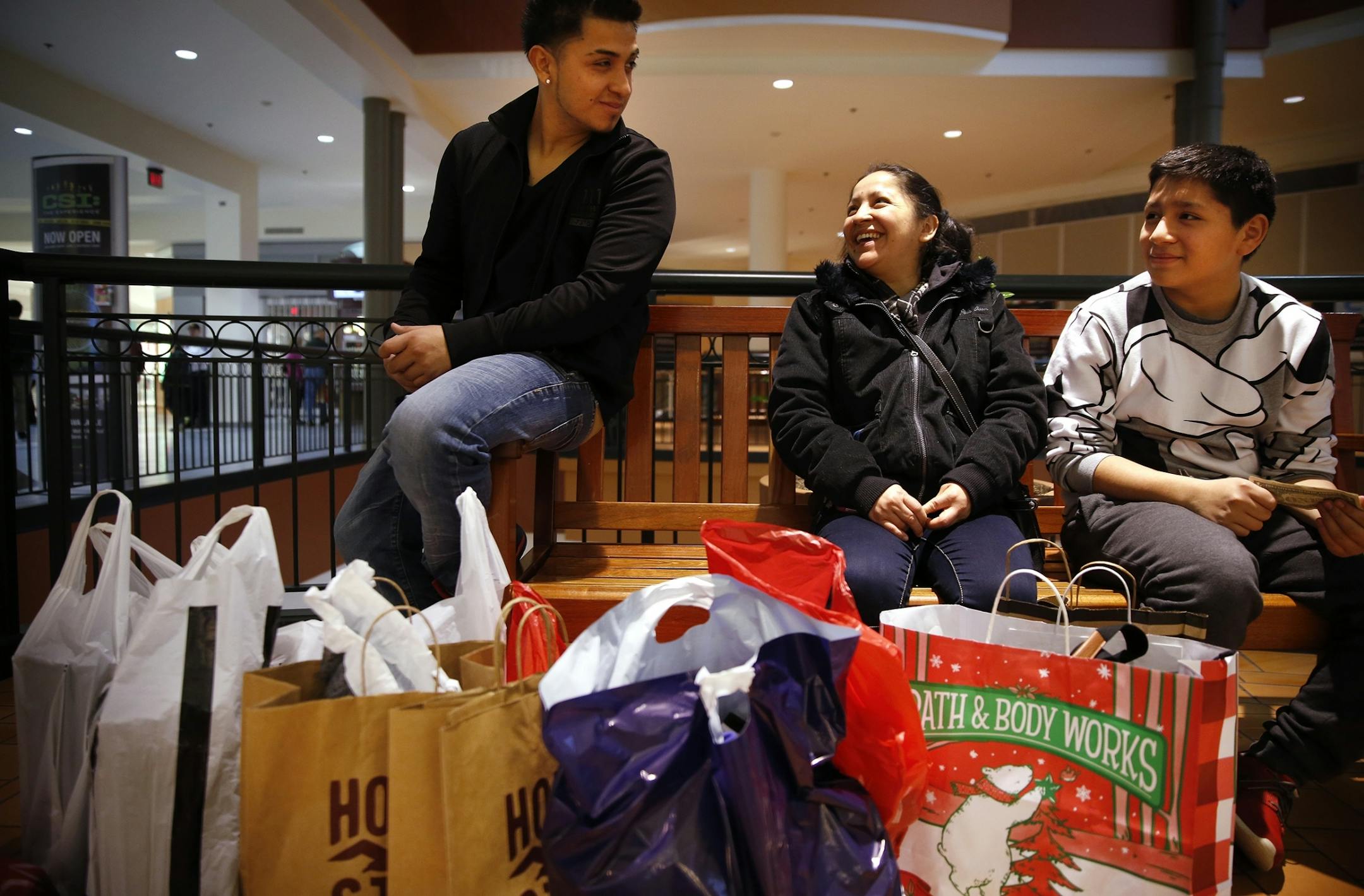 Livia Vasquez, center, of Minneapolis rests while shopping with her sons Jorge Vasquez, left, 20, and Javier Vasquez, 13, at Mall of America in Bloomington on Friday, November 28, 2014.