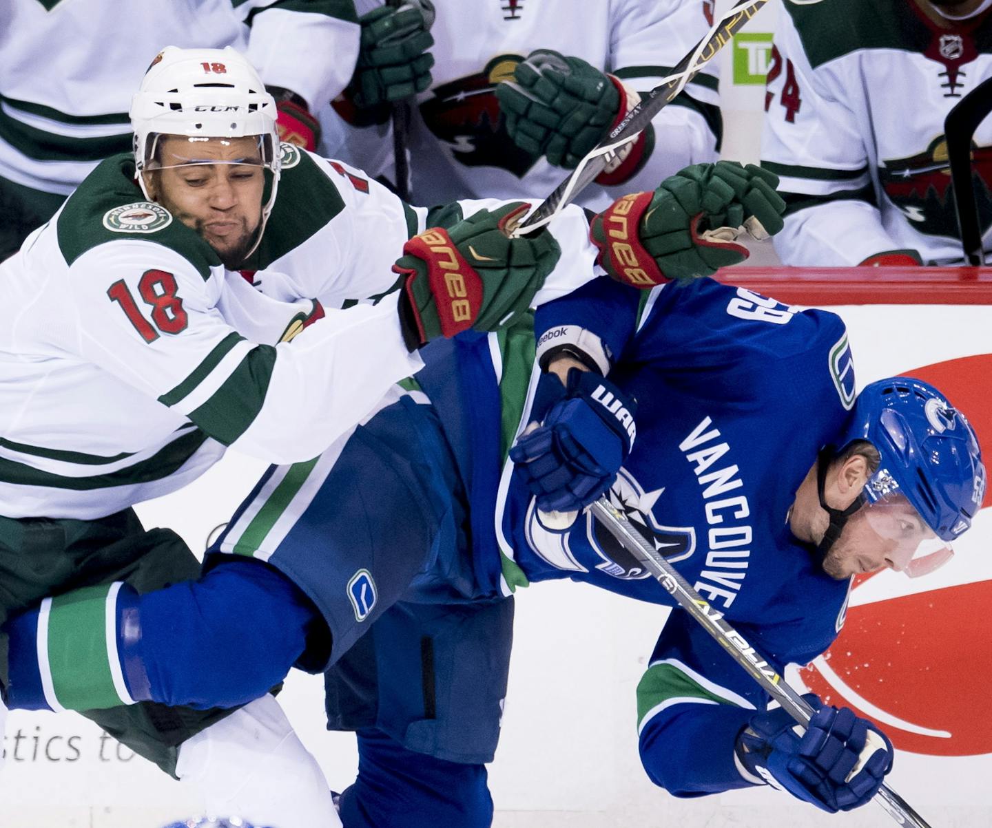 Minnesota Wild left wing Jordan Greenway (18) fights for control of the puck with Vancouver Canucks center Tim Schaller (59) during the second period of an NHL hockey game, Monday, Oct. 29, 2018, in Vancouver, British Columbia. (Jonathan Hayward/The Canadian Press via AP)