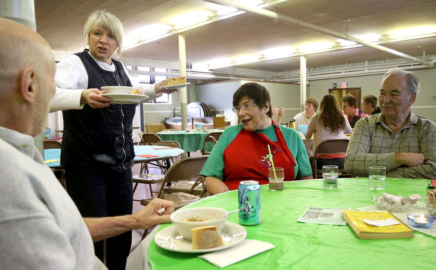 Volunteer waitress Sherry Reagan of St. Paul stops to chat to fellow volunteer Owen Green, left, and diners Valerie Ludvigson, center, and her dad Doug of Minneapolis at the Soup for You! Cafe Tuesday, March 31, 2015, at Bethany Lutheran Church in Minneapolis, MN.](DAVID JOLES/STARTRIBINE)djoles@startribune.com A Lutheran pastor (Mike Matson) and a refugee from Tunisia (Judah Nataf) have joined forces to redefine the soup kitchen. The gourmet soup they prepare is mostly organic. The clientele is