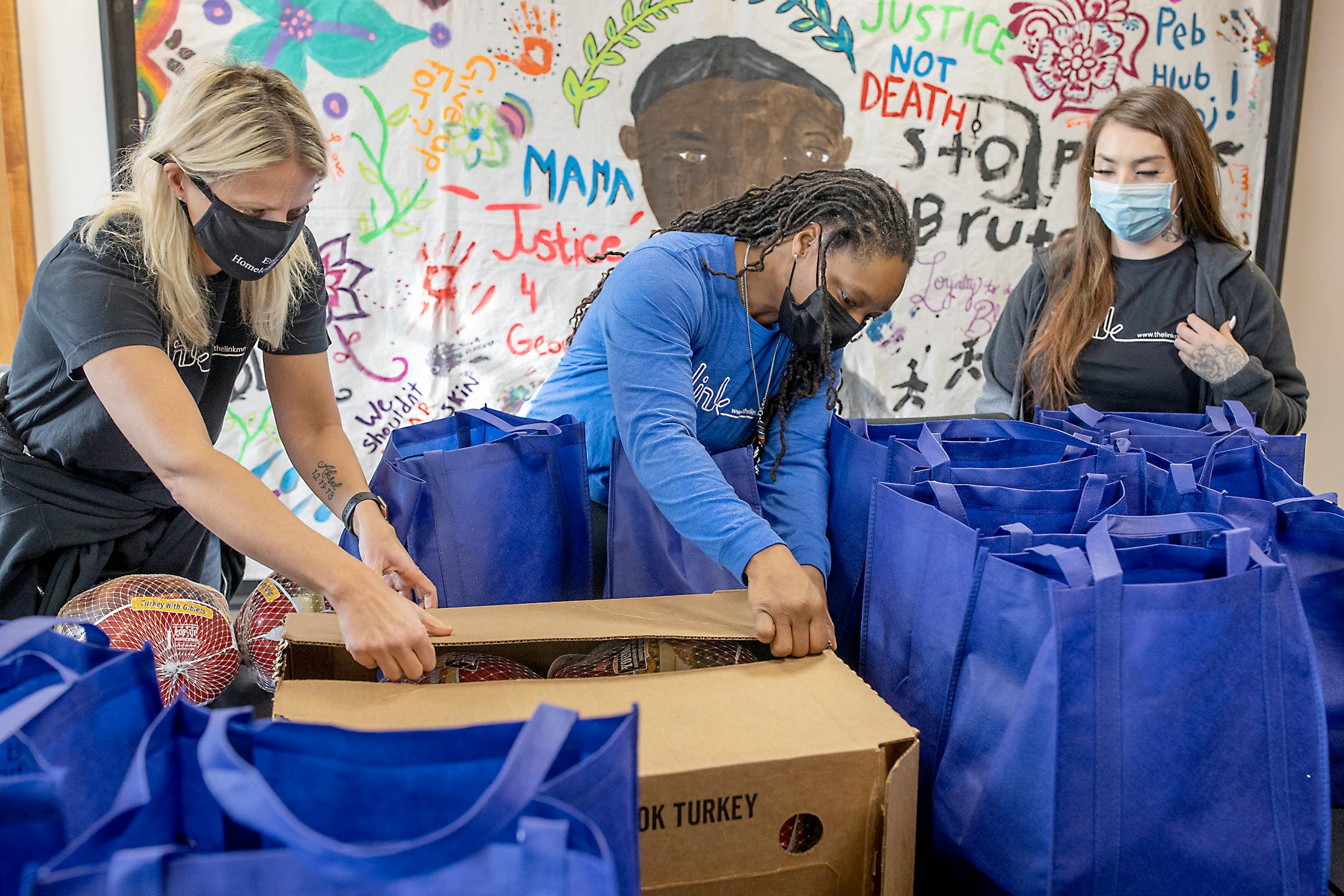 The Link's CEO Beth Holger, left, Kesha Bradford, the housing and support services director, center and Angel Otis, unload Thanksgiving donations from the Vikings to their headquarters in Minneapolis, Minn., on Tuesday, November 23, 2021. The non-profit founded three decades ago by two former Minnesota Vikings, recently received the biggest single donation in the group's history: $2.5 million from the Bezos Day 1 Families Fund. It will go to fight family homelessness in the Twin Cities. ] Elizabeth Flores • liz.flores@startribune.com