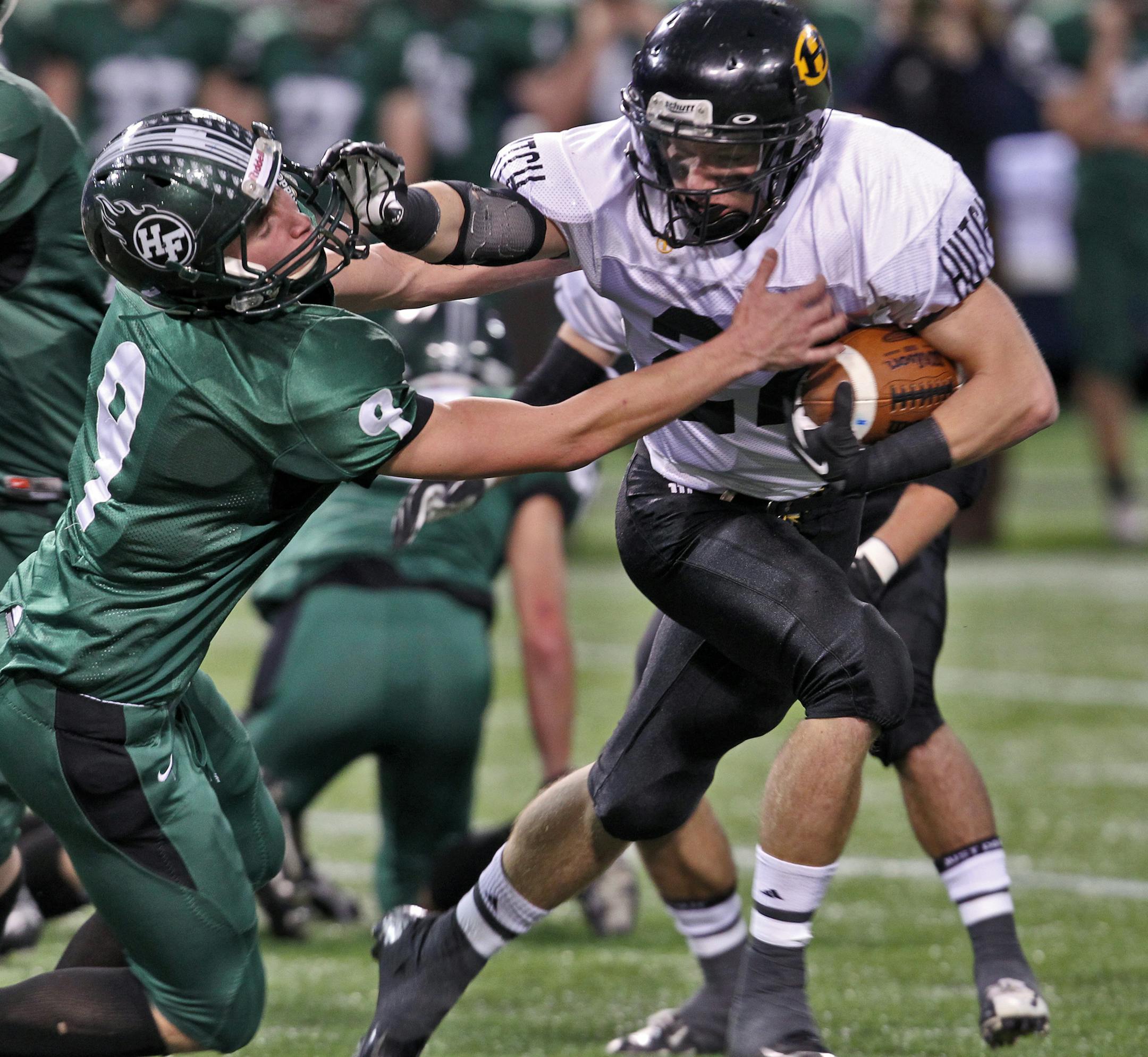 Prep Bowl Championship - 4A - Holy Family Catholic vs. Hutchinson. Hutchinson's Tory Adams (22) stiff-armed his way past Holy Family defender Rob LaRose (9). (MARLIN LEVISON/STARTRIBUNE(mlevison@startribune.com (cq - all names program) ORG XMIT: MIN1211231740490403