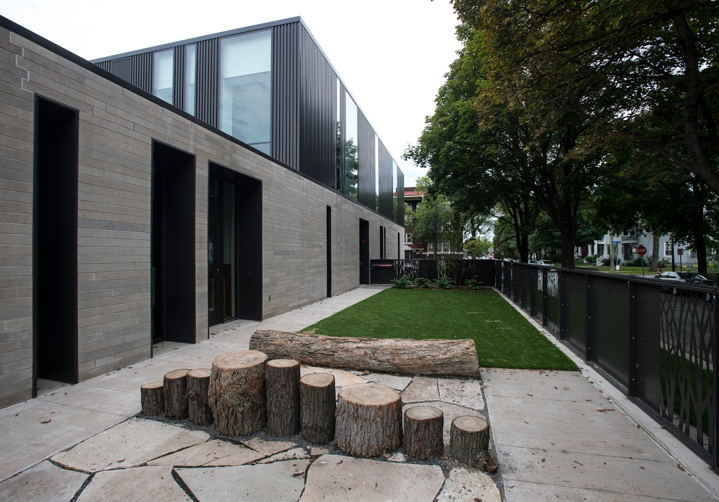 A play area for the one-story Early Childhood Center steps up in a glass-and-metal second story that houses new classrooms.