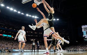 Purdue center Zach Edey dunks over UConn center Donovan Clingan, left, during the first half of the NCAA men's basketball national championship game.