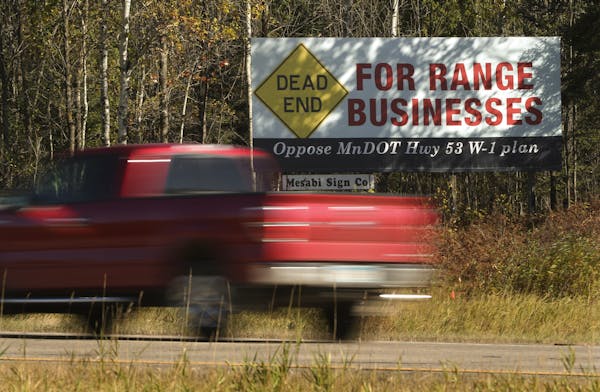 A billboard on Highway 53 Wednesday morning in Eveleth was part of a campaign against the relocation scenario that would bypass Eveleth. ] JEFF WHEELE