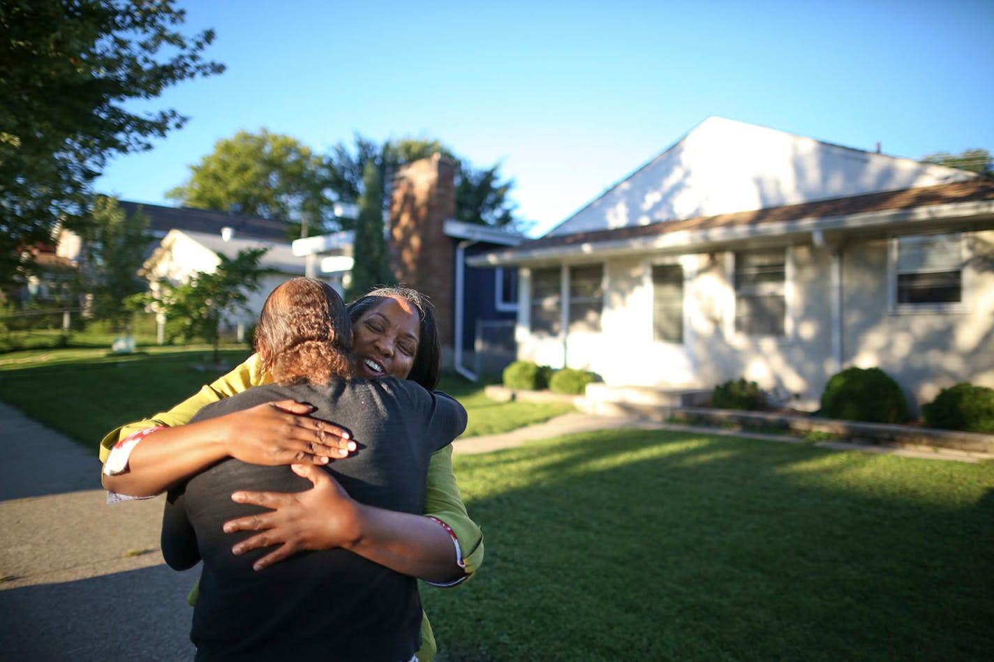 Kelly Martin, facing camera, who grew up in the Tilsenbilt home behind her, had a hug for her former neighbor, Kim Collins.