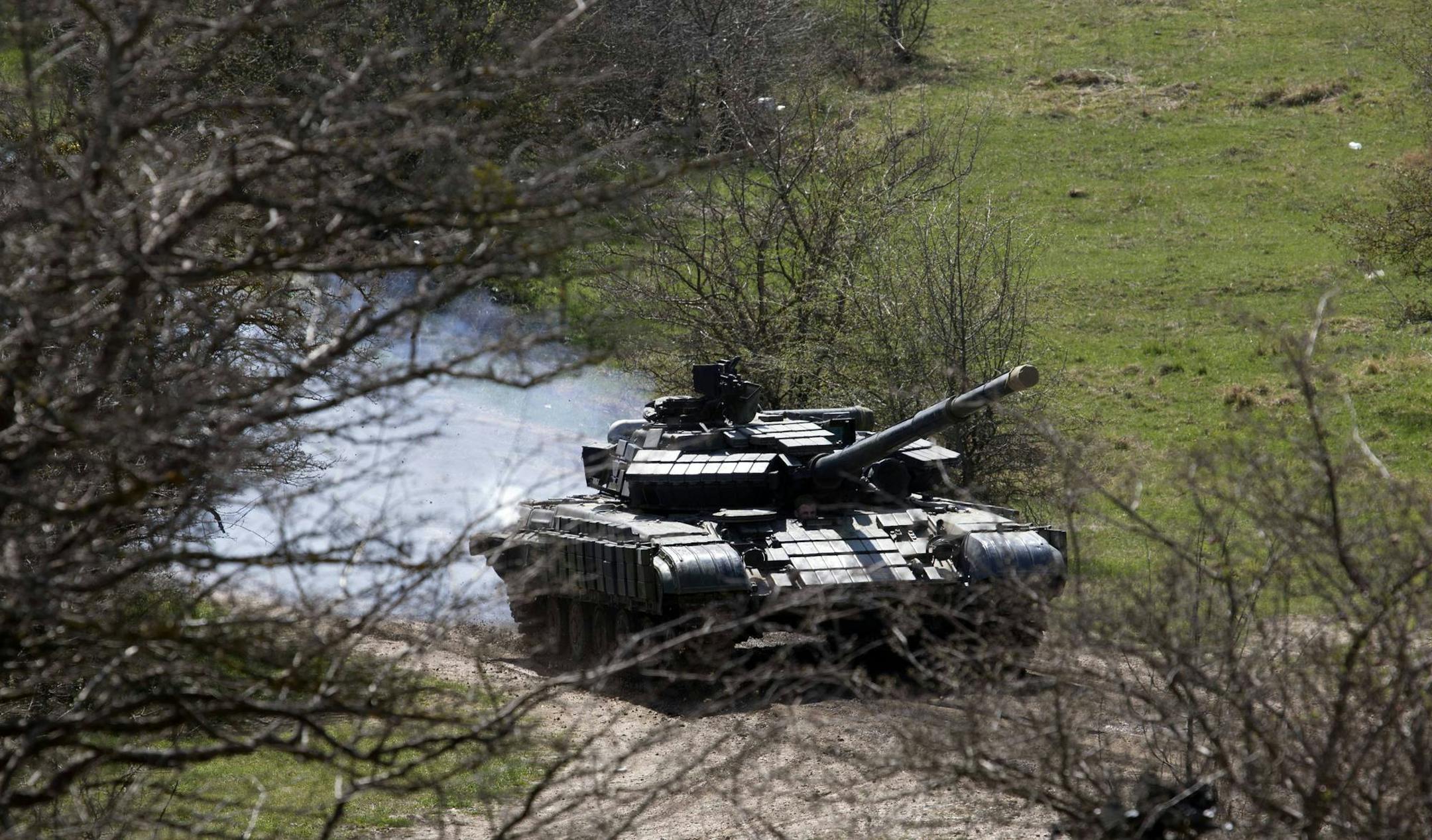 A tank maneuvers near a former Ukrainian military base in Perevalne, outside Simferopol, Crimea, March 27, 2014. Russia last week completed the annexation of Crimea following a referendum in which an overwhelming number of residents voted to break off from Ukraine and join Russia. The vote, rejected by Ukraine and the West, was hastily called after Russian forces had overtaken the peninsula.(AP Photo/Pavel Golovkin)