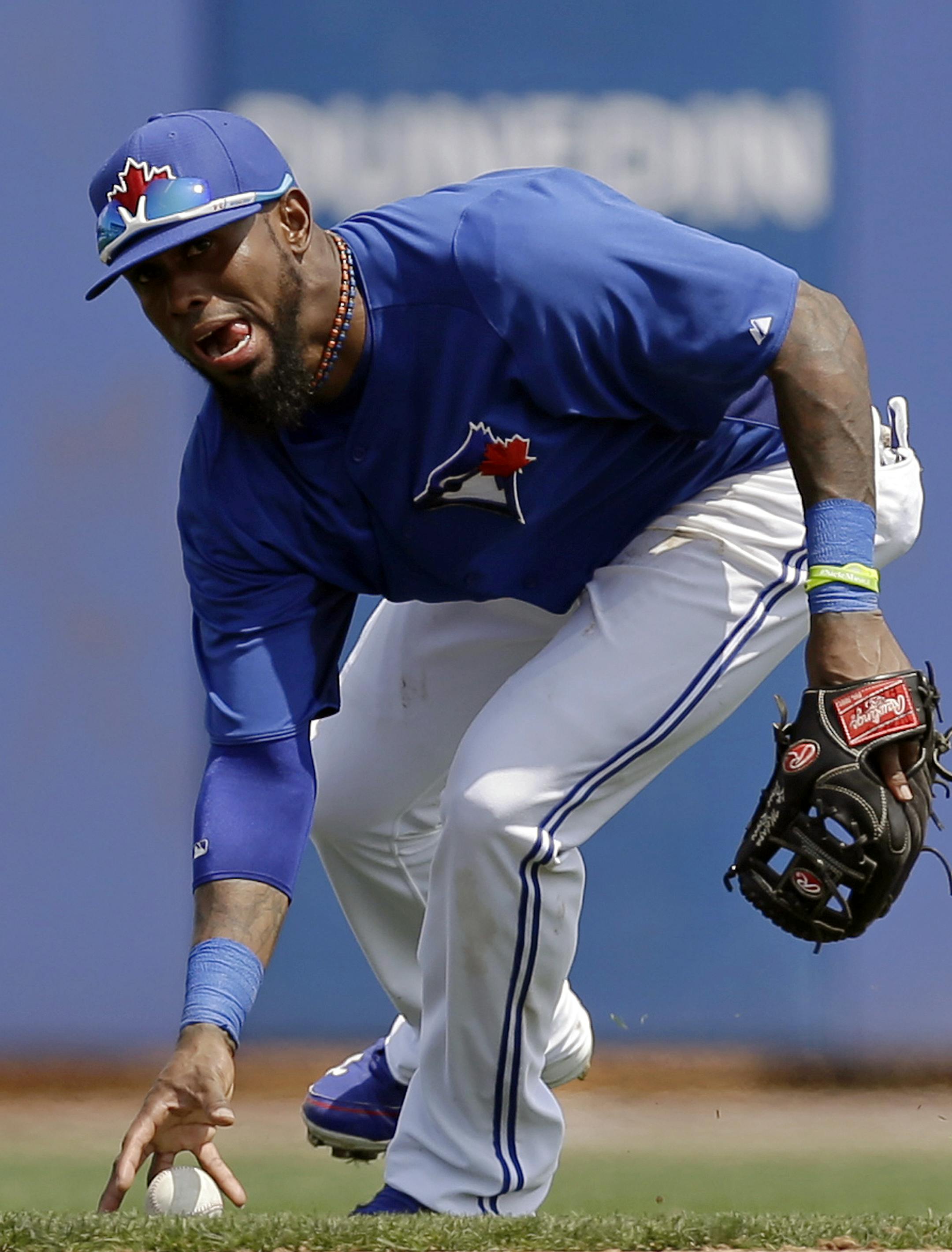 Toronto Blue Jays shortstop Jose Reyes (7) reacts after bobbling Justin Upton's RBI single that allowed the Braves Reed Johnson to score the go-ahead run in the fifth inning of a spring training baseball game in Dunedin, Fla., Saturday, March 23, 2013. (AP Photo/Kathy Willens)