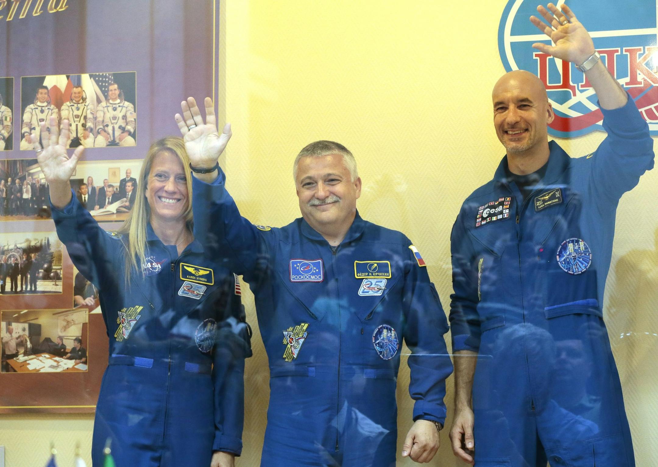 Members of the next mission to the International Space Station, U.S. astronaut Karen Nyberg, left, Russian cosmonaut Fyodor Yurchikhin, center, and European Space Agency astronaut Luca Parmitano pose for the media after a news conference in Russian leased Baikonur cosmodrome, Kazakhstan, Monday, May 27, 2013. The start of the new Soyuz mission is scheduled on Wednesday, May 29. (AP Photo/Mikhail Metzel)
