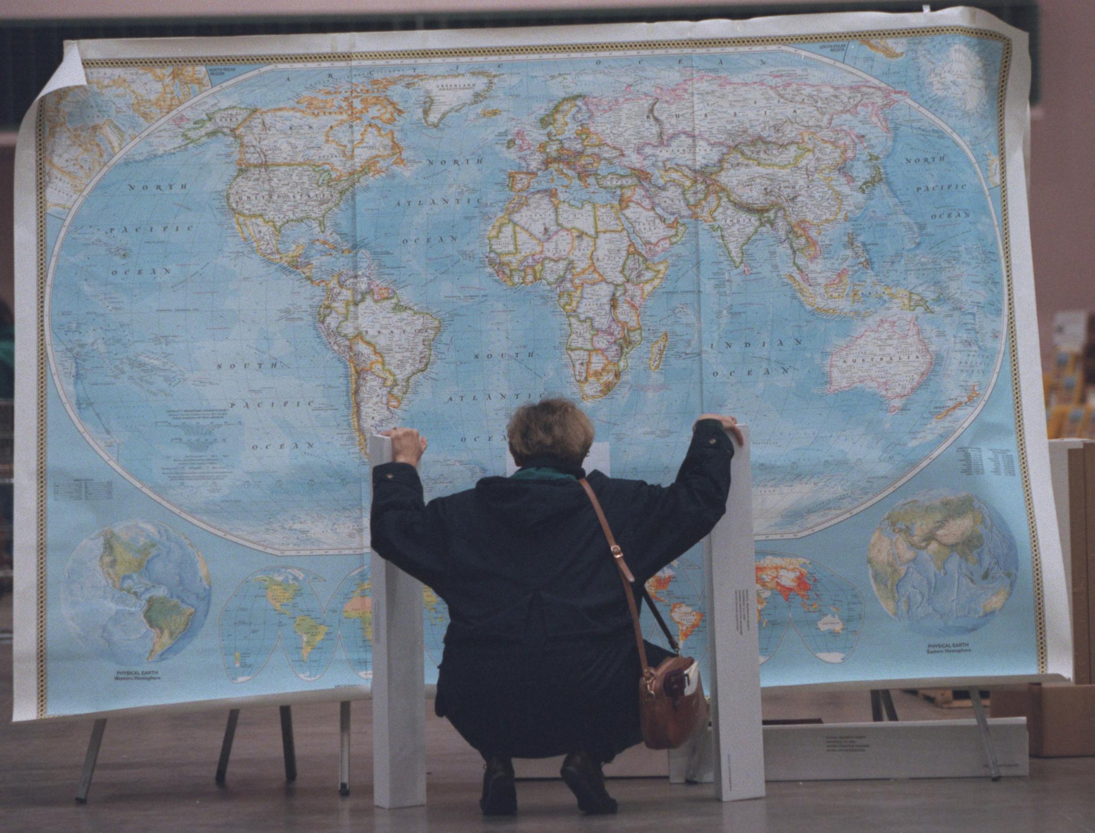 This woman carefully scrutinized a large 3 panel map of the world at the National Geographic Society warehouse sale at the Minneapolis Convention Center.