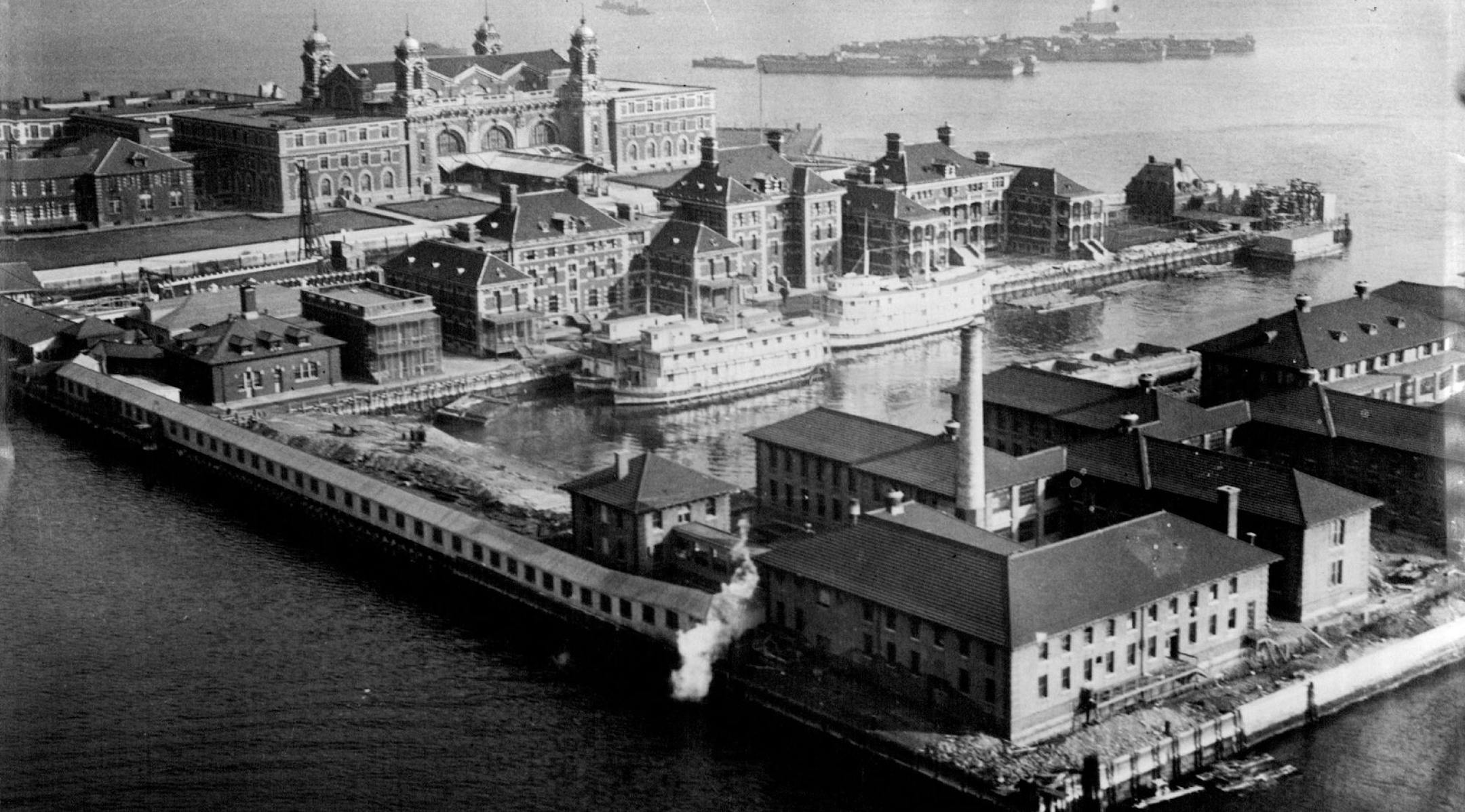 July 1, 1923 Above is shown an aerial view of the immigration station at Ellis Island, which has been handed an&#xc2;&#xad;other sound trouncing in the British House of Commons where the suggestion was ad&#xc2;&#xad;vanced that Great Britain ought to adopt retaliatory methods if the Ameri&#xc2;&#xad;can government did not change its method of detaining British subjects at Ellis Island. The subject was introduced when a member of the House inquired how many British subjects were "incarer&#xc2;&#x
