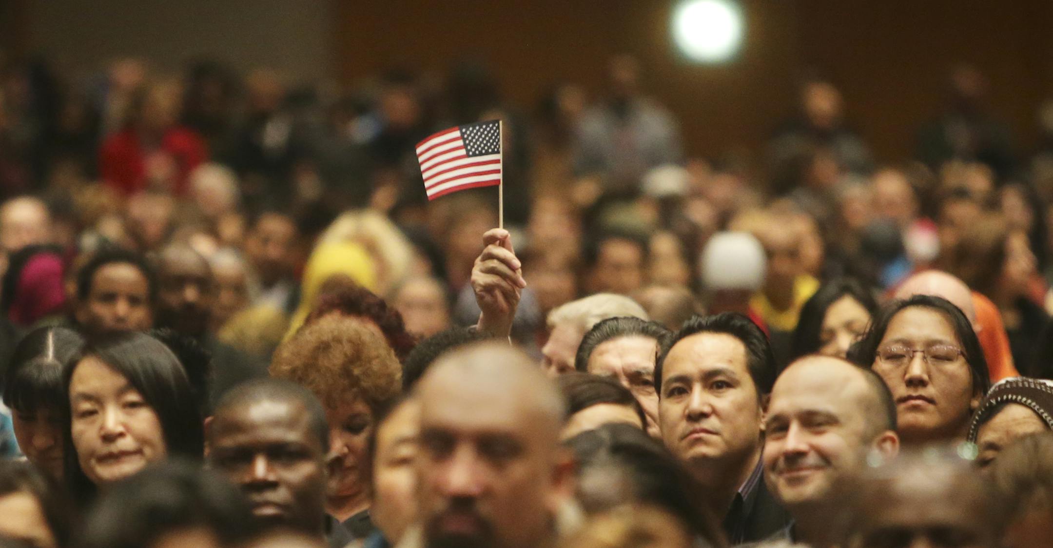 During a Naturalization ceremony for 1,501 immigrants comprising hundreds of countries, a man held his American flag up at the Minneapolis Convention Center, Tuesday, Jan. 21, 2014, in Minneapolis, MN.](DAVID JOLES/STARTRIBUNE) djoles@startribune.com A Naturalization ceremony for 1,501 immigrants comprising hundreds of countries was held at the Minneapolis Convention Center. Following the ceremony, 85 percent of the new citizens were scheduled to turn in voting papers allowing them to vote for t