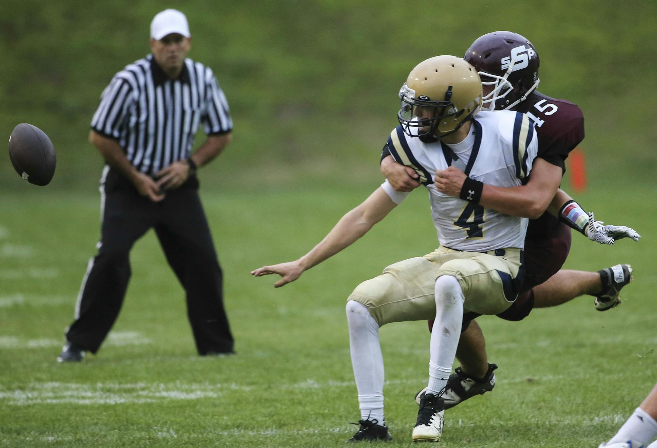 Chanhassen High quarterback Maxon Hutton (4) is hurried by South St. Paul tackler Korey O'Donnell (45) as Hutton threw an errand pitch that was recovered by Chanhassen Friday, Aug. 22, 2014, at Ettinger Field at South St. Paul High in South St. Paul, MN. ] (DAVID JOLES/STARTRIBUNE) djoles@startribune Start of prep football , Chanhassen at South St. Paul.** Maxon Hutton, Korey O'Donnell,cq