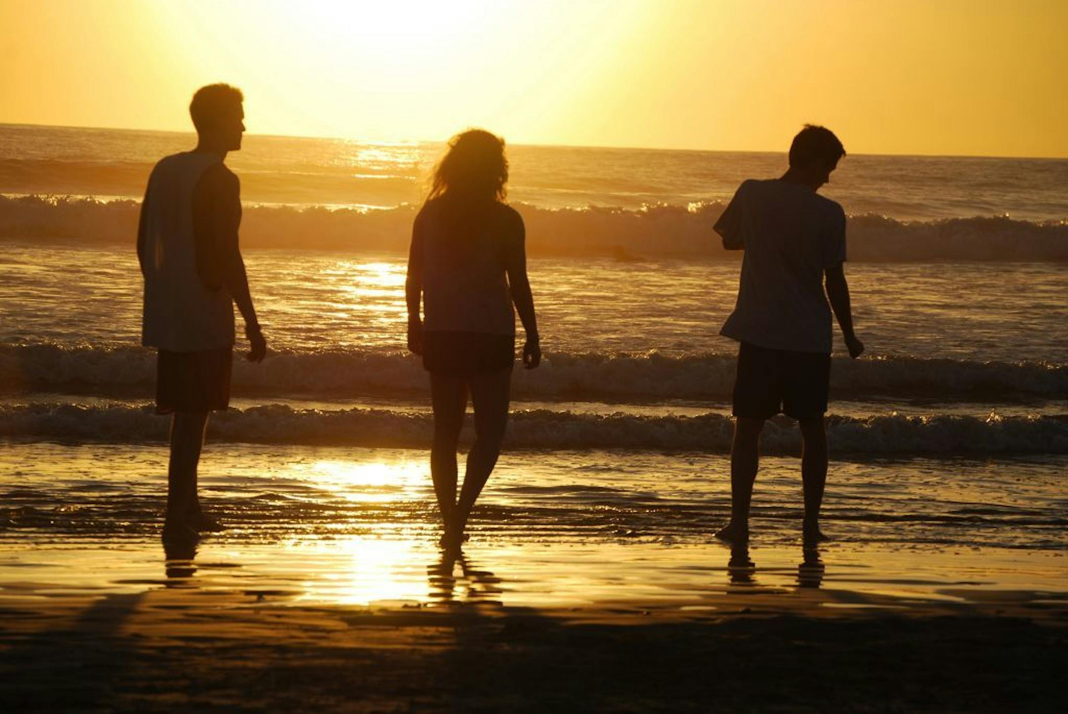 This February 2014 photo released by Kristina MacKulin shows, from left, Liam Godfrey-Jolicoeur, Ruby Dombek and Jacob Dombek of N. Ferrisburg Vt. watching the sunset at Playa Guiones in Nosara, Costa Rica. Nosara is a scenic coastal region with a variety of outdoor recreation activities for visitors.