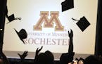 Following the graduation ceremony, the first-ever class of graduates at the University of Minnesota, Rochester toss their mortar boards into the air a