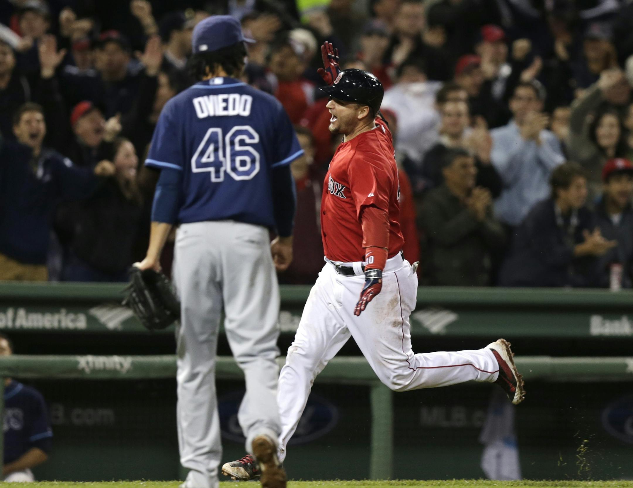 Boston Red Sox's A.J. Pierzynski celebrates as he passes Tampa Bay Rays relief pitcher Juan Carlos Oviedo (46) after his game-winning RBI triple during the 10th inning of a baseball game at Fenway Park in Boston, Friday, May 30, 2014. The Red Sox defeated the Rays 3-2. (AP Photo/Charles Krupa)