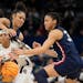South Carolina's Destanni Henderson is fouled as she drives between UConn's Olivia Nelson-Ododa, right, and Azzi Fudd during the second half