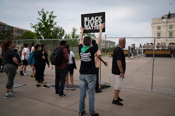 A small group of protesters by the fence surrounding the Minnesota State Capitol in St. Paul on June 19, 2020.