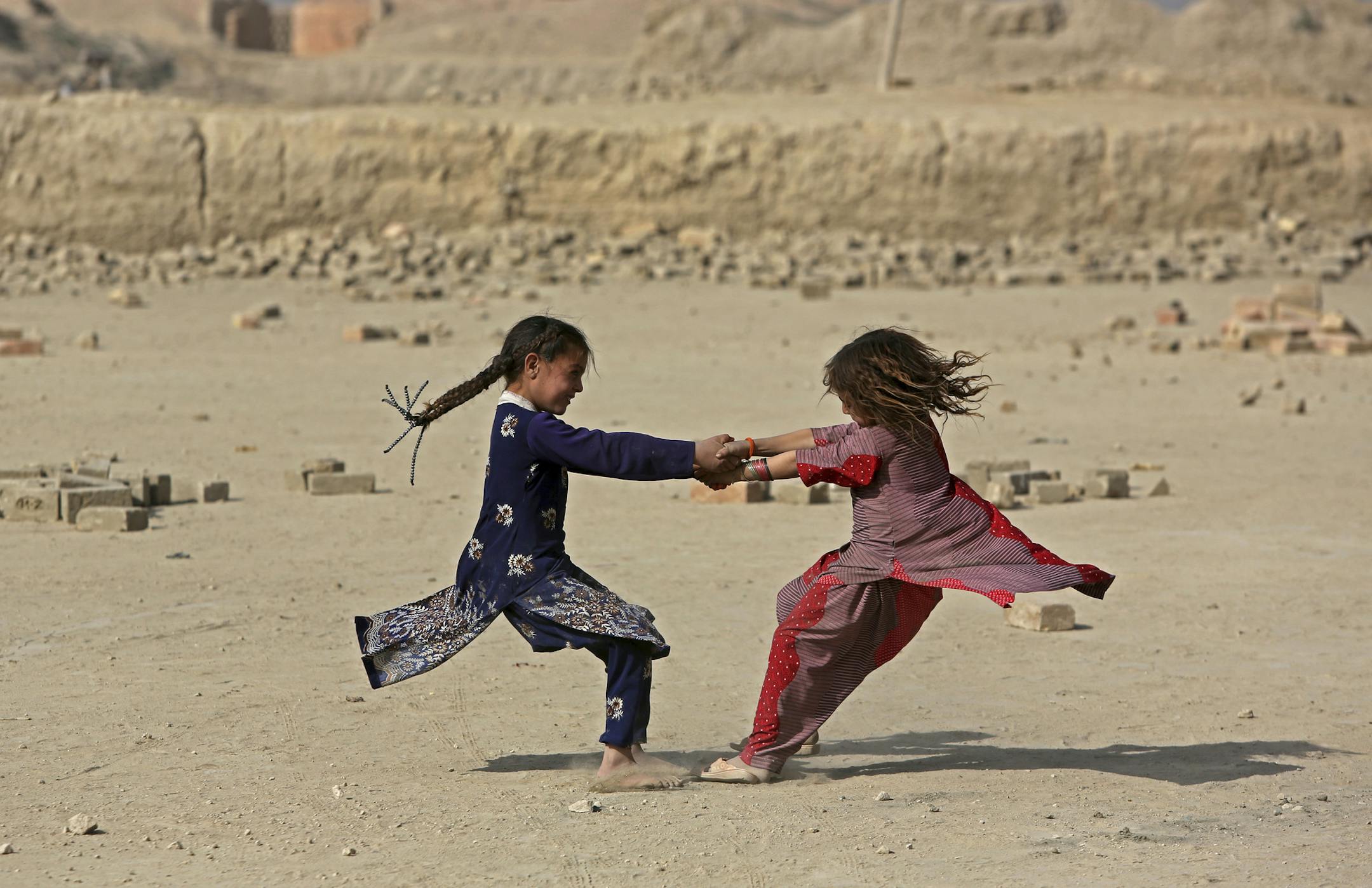 Afghan girls play on the outskirts of Kabul, Afghanistan, Tuesday, Oct. 4, 2016, (AP Photo/Rahmat Gul)